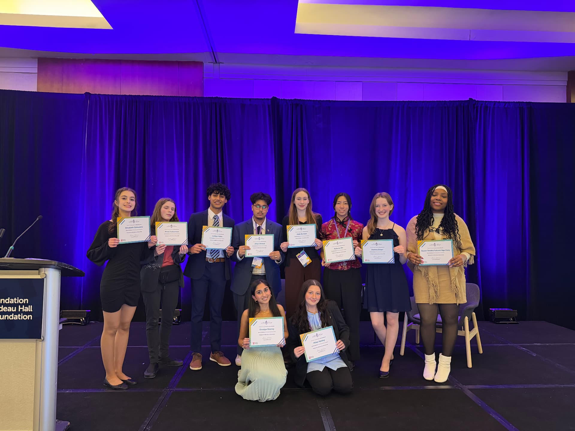Forum for Young Canadians group holding certificates on stage
